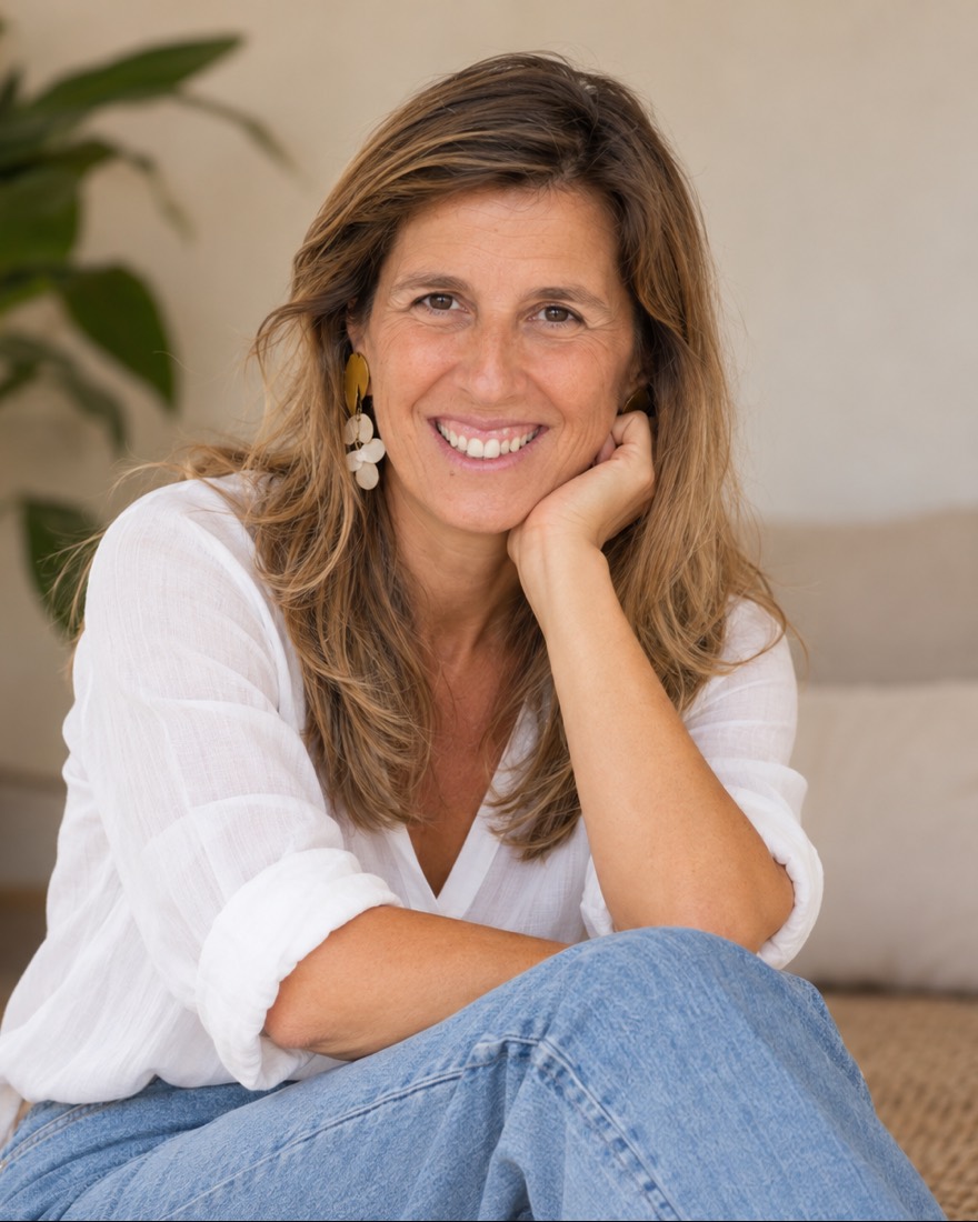 Joana Rombert, sorridente, com a mão no queixo